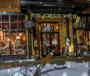 Une devanture de magasin avec une enseigne indiquant « PEND JOREILLE WINERY » et un sol recouvert de neige.