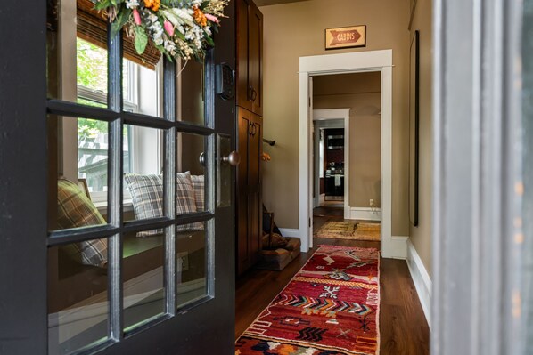 A hallway with a wooden door, a rug, and a sign indicating 'CABINS'. - Couples Retreat: King+ Sauna + HotTub I Downtown (Sandpoint)