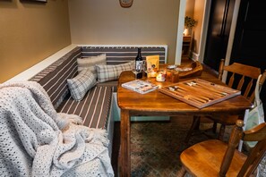 A cozy seating area with a bench, a table with a board game, and a candle.