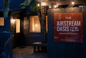 Eine Holzhütte mit einem Schild für 'The Airstream Oasis' in Sandpoint, Idaho.