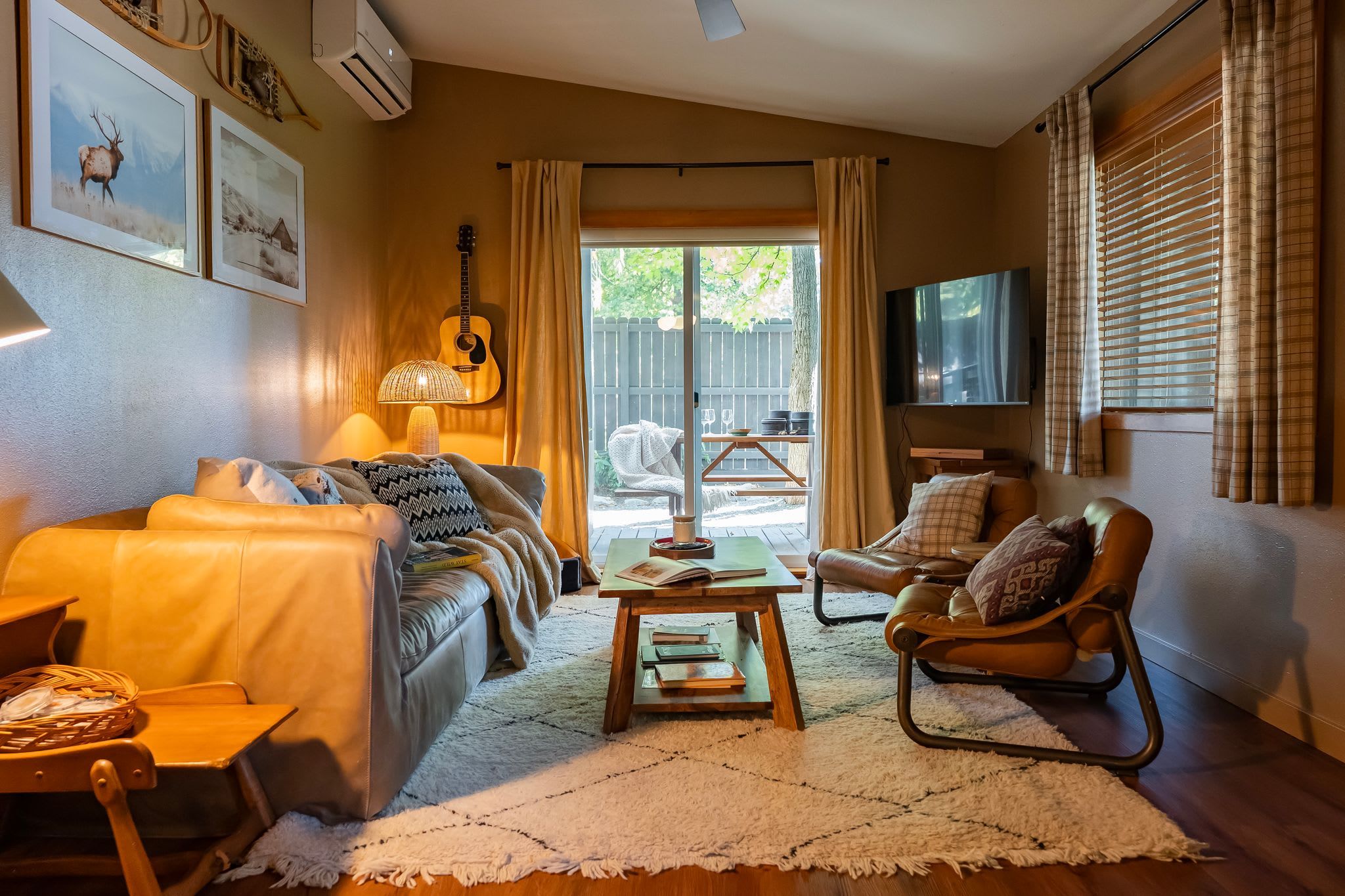A cozy living room with a sofa, armchair, coffee table, and a television.