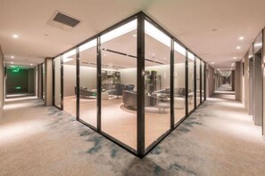 A modern hotel corridor with glass partitions, a reception area, and a staircase. - Homeinn Selected(Beijing National Stadium Branch) (Beijing)