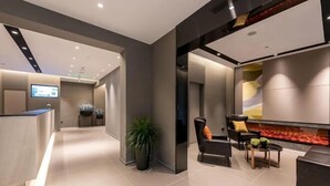 Un hall d’entrée moderne avec un comptoir d’accueil, un espace salon et une cheminée.