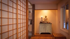 A room with a wooden floor, a white cabinet with a statue, and a sliding door with a grid pattern. - The Race Mountain House (Sheffield)