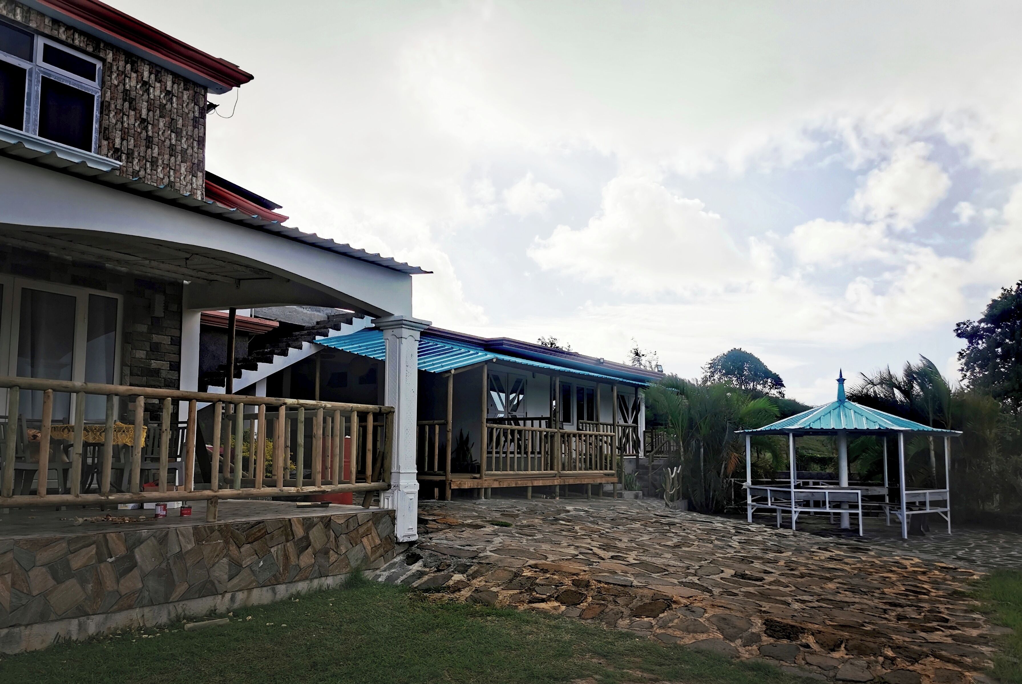 A house with a stone facade, a wooden deck, and a gazebo.