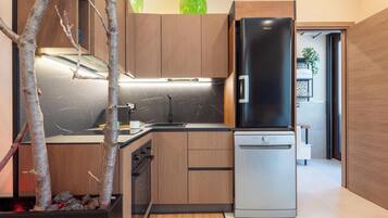 A modern kitchen with wooden cabinets, a black refrigerator, and a dishwasher.