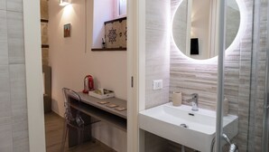 A modern bathroom with a white sink, a round mirror, and a shower enclosure. - Barlaman Luxury Rooms (Palermo)