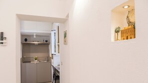 A narrow hallway leading to a kitchen with cabinets and a dining area. - Barlaman Luxury Rooms (Palermo)