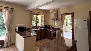 A spacious kitchen with a large island, wooden cabinets, and a white refrigerator. - Domain of a farmhouse and a house to meet (Peymeinade)