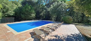 A rectangular swimming pool with a tiled deck and lounge chairs. - A farmstead consisting of a farmhouse and a community center (Peymeinade)