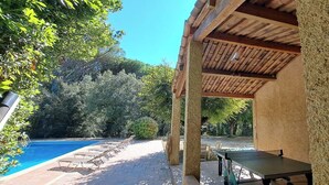 A covered outdoor area with a pool, lounge chairs, and a ping pong table. - Domain of a farmhouse and a house to meet (Peymeinade)