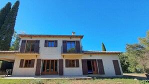 A two-story house with a balcony, large windows, and a tiled roof. - Domain of a farmhouse and a house to meet (Peymeinade)