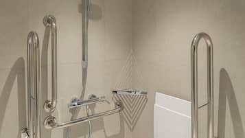 A modern bathroom with a walk-in shower, grab bars, and a handheld showerhead.