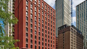 A multi-story building with a red brick facade and numerous windows.