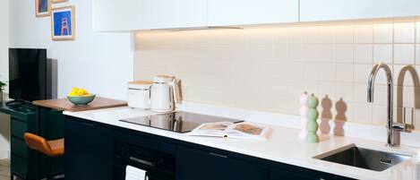 A modern kitchen with a central island, built-in appliances, and a large window.