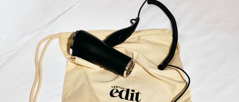 A bed with a beige drawstring bag on it.