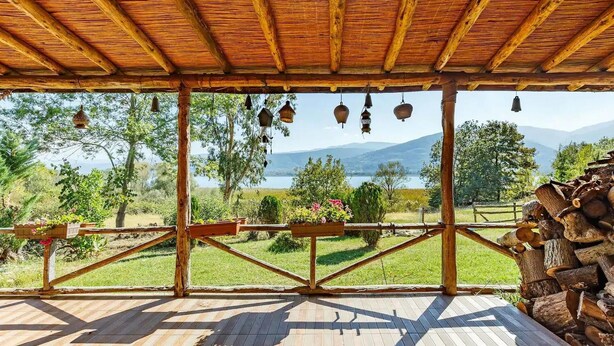 Eine Holzterrasse mit Blick auf einen See und Berge.