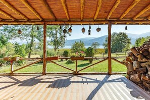 Una terraza de madera con vista a un lago y montañas.