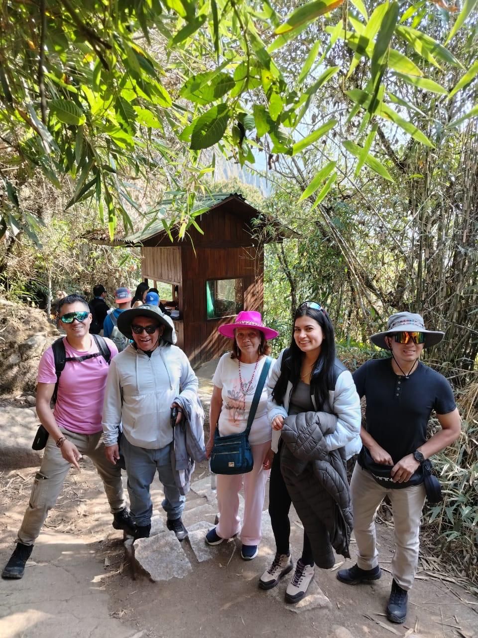 Un grupo de personas caminando hacia una estructura de madera en un área boscosa.