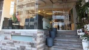 A hotel entrance with a glass facade, a stone facade, and a number '108' above the door. - Tours Machu Picchu Perù Hotel (Cusco)