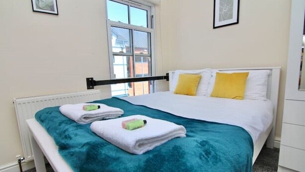 A bedroom with a bed, a window, and a radiator. - LHR Studio 4 - Coventry (Coventry)