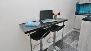 A small kitchenette with a laptop on a table, a vase with flowers, and a book. - LHR Studio 4 - Coventry (Coventry)