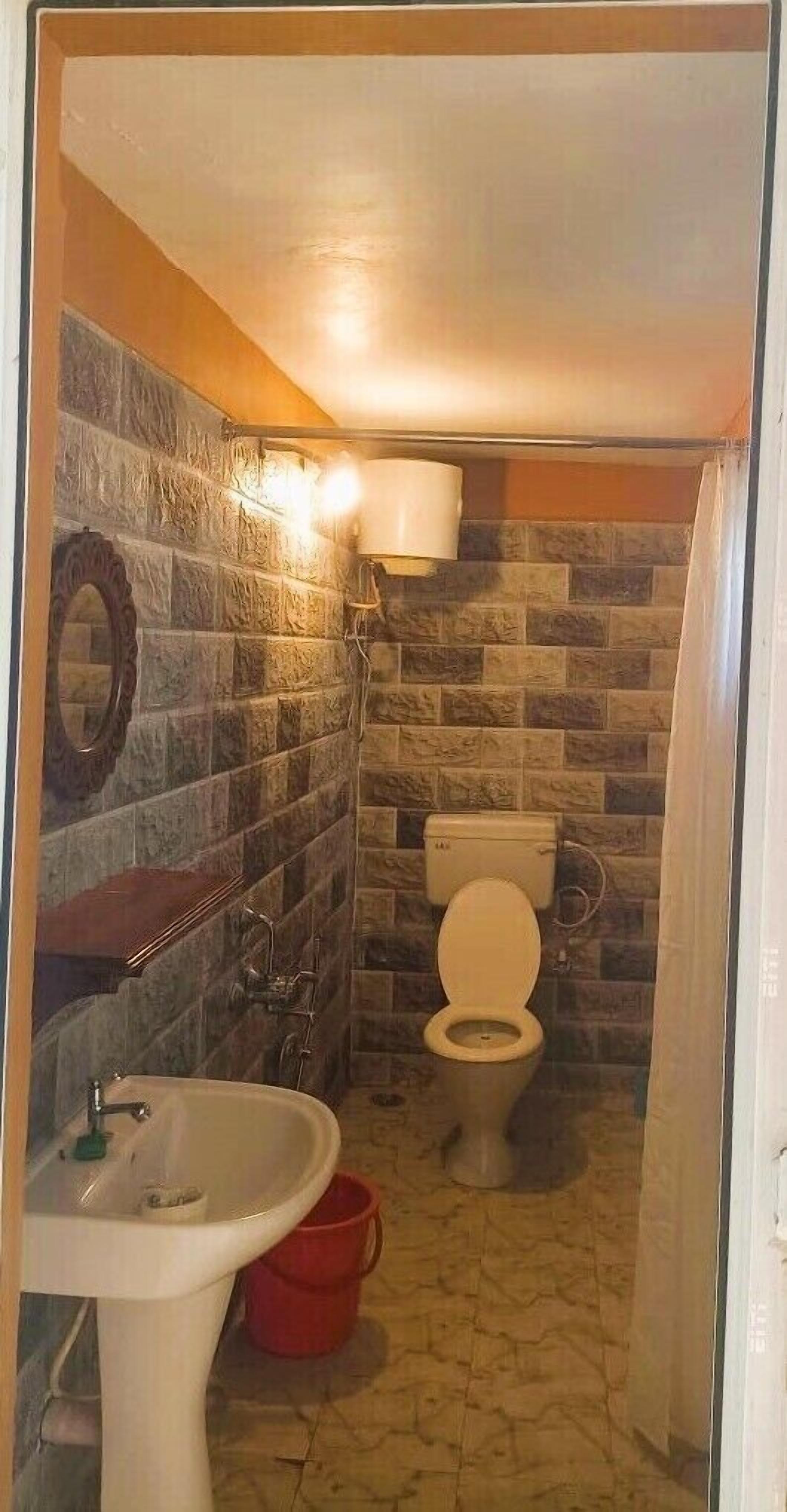 A bathroom with a toilet, sink, and shower.