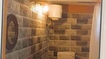A bathroom with a toilet, sink, and shower.