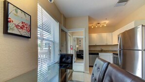 A compact living space with a kitchenette, a dining area with a leather couch, and a small TV. - Apartment for 2 guests (Sarasota)