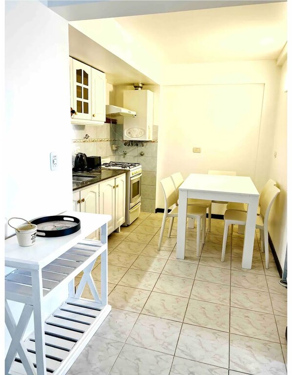Prepare meals in the central island kitchen with stove and oven, then dine at the adjacent table and chairs.