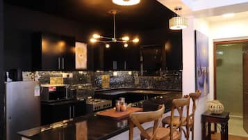Deluxe Apartment, City View | Private kitchen | Microwave, cookware/dishes/utensils, dining tables