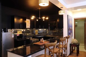 Deluxe Apartment, City View | Private kitchen | Microwave, cookware/dishes/utensils, dining tables