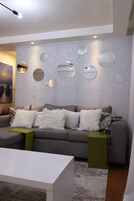 Apartamento Deluxe, vistas a la ciudad | Zona de estar | Smart TV de 24 pulgadas con canales digitales