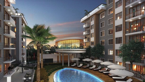 Un hôtel moderne doté d’une piscine sur le toit, de chaises longues et d’un atrium en verre.