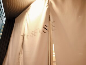 A curtain with the text "THESEUS" partially visible.