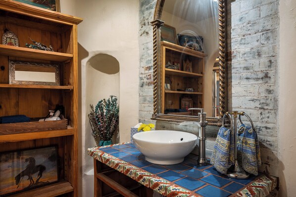 A bathroom with a white sink, wooden shelves, and a mirror. - Steps to the Historic Santa Fe Plaza (Santa Fe)