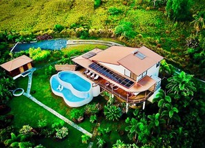 A large house with a swimming pool, multiple decks, and a lush garden. - Gone Tropical Luxury Villa St Lucia (Delcer)