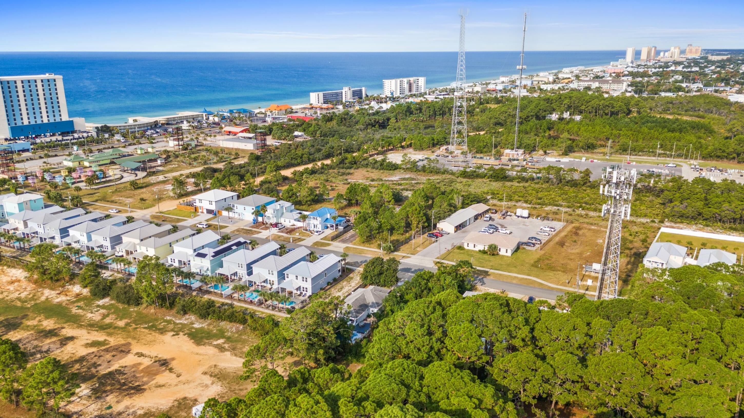 Vista aérea de una zona residencial costera con edificios de varios pisos, un puerto deportivo y una gran torre de comunicaciones.