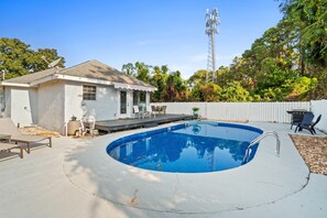 A backyard with a swimming pool, a barbecue area, and a house with a satellite dish. - Barefoot Beach House by PHG (Panama City Beach)