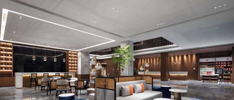 A modern hotel lobby with a seating area, a reception desk, and a plant.