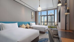 A hotel room with two beds, a desk, and a view of a cityscape. - Hilton Garden Inn Luoyang Kaiyuan Avenue (Luoyang)
