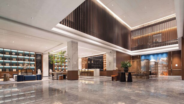 A spacious lobby with a high ceiling, a reception desk, seating areas, and a decorative wall with a patterned design. - Hilton Garden Inn Luoyang Kaiyuan Avenue (Luoyang)