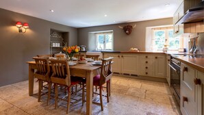 A kitchen with a dining table, chairs, and a window.