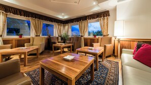 A hotel room with a wooden floor, a sofa, two armchairs, a coffee table, and a TV. - Residence Mathilda in the Vinschgau apple orchard - Refined & simple (Schlanders)