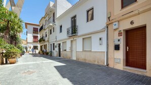 A narrow street lined with white buildings, some with balconies and potted plants. - Apartment with Sea Views (Jávea)