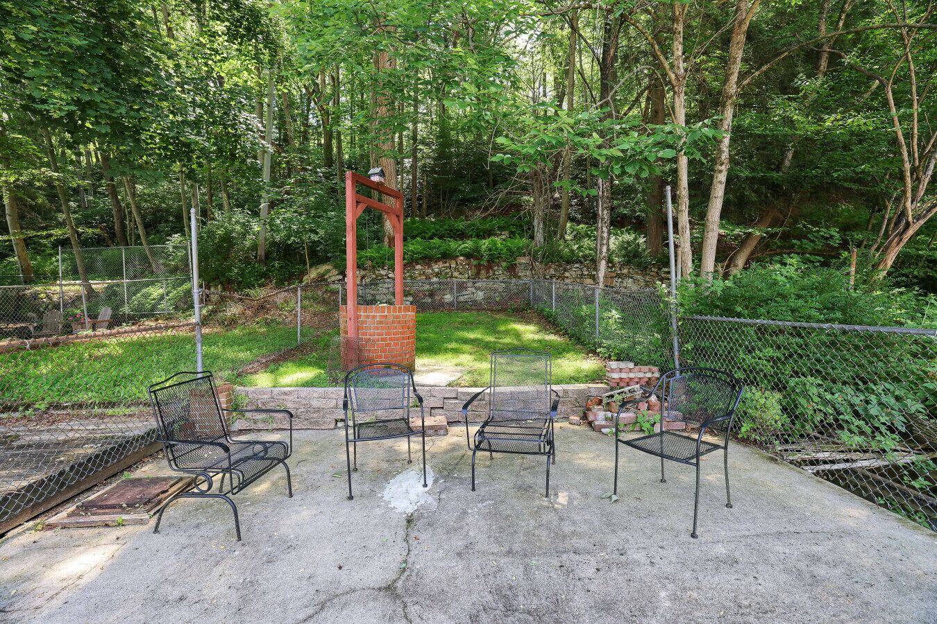 A patio area with metal chairs and a brick chimney.