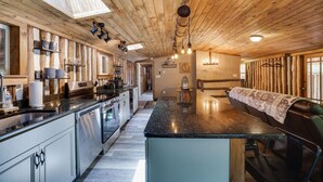 A spacious kitchen with a central island, wooden ceiling, and modern appliances. - Cozy Log Cabin in Jim Thorpe (Jim Thorpe)