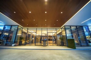 A modern building entrance with glass doors and a wooden ceiling. - Bayprime Hotel (Paranaque)