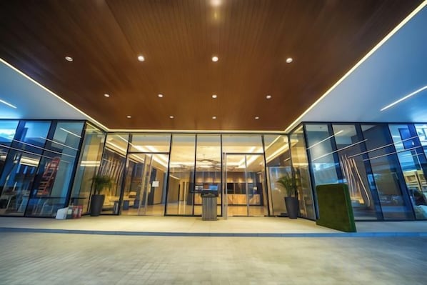 Une entrée moderne avec des portes en verre et un plafond en bois.