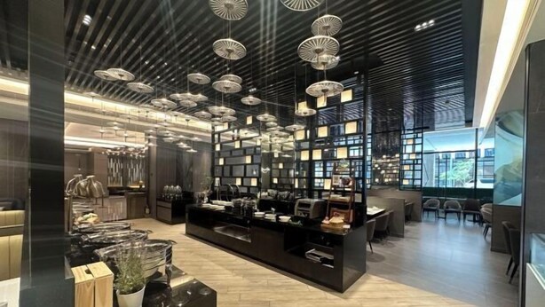 Un intérieur moderne avec un comptoir central, des luminaires suspendus et un espace salon.